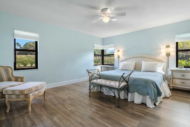 bedroom featuring ceiling fan, wood-type flooring, and multiple windows