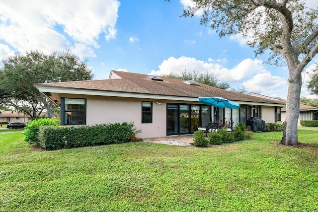 rear view of house featuring a lawn