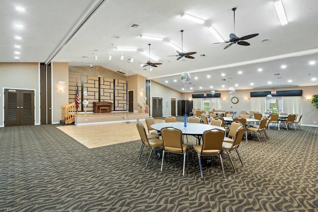 dining area featuring high vaulted ceiling, dark carpet, and ceiling fan