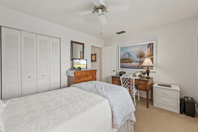 bedroom featuring ceiling fan, a closet, and light carpet