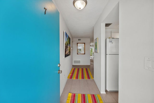 hallway with light tile patterned floors and a textured ceiling