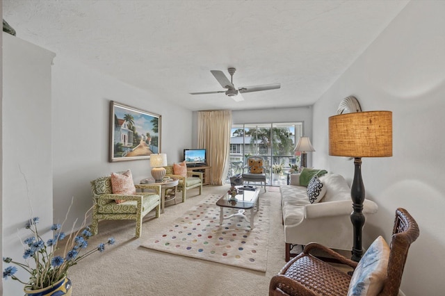 carpeted living room featuring ceiling fan and a textured ceiling