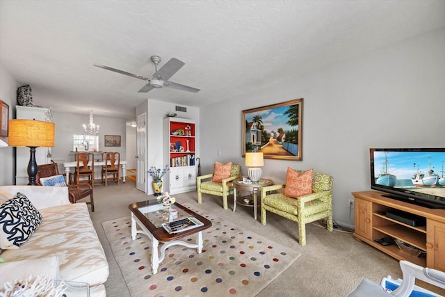 carpeted living room with ceiling fan with notable chandelier and a textured ceiling