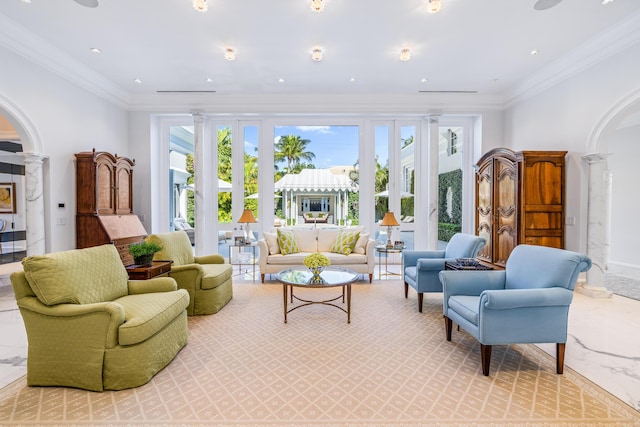 living area featuring decorative columns, arched walkways, and ornamental molding