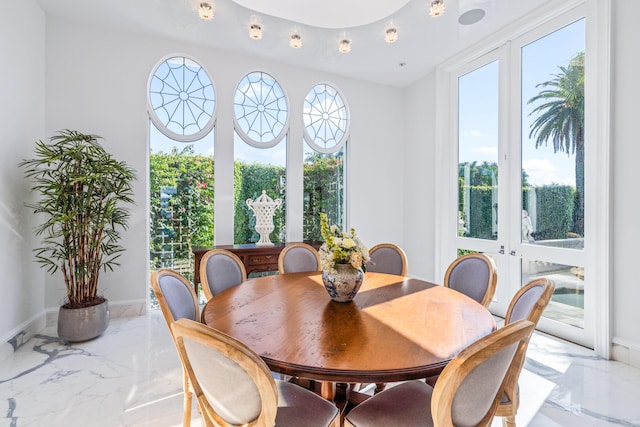 dining room featuring marble finish floor, plenty of natural light, baseboards, and french doors