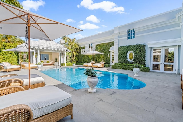 pool featuring an outbuilding, a patio, french doors, and a storage structure