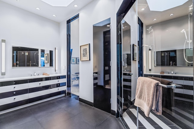 bathroom featuring a stall shower, a skylight, vanity, and a high ceiling