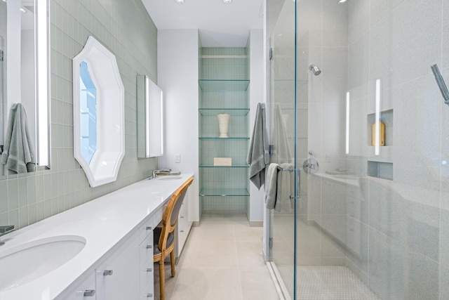 full bath with tile walls, double vanity, a stall shower, a sink, and tile patterned floors