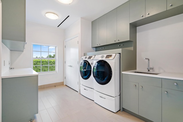 laundry room featuring cabinet space, a sink, and washing machine and clothes dryer