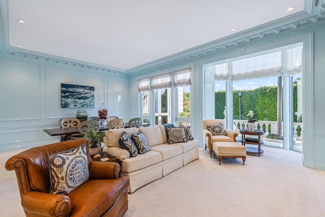 living area with ornamental molding, carpet, a decorative wall, and recessed lighting