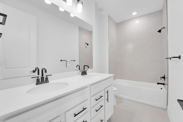 full bathroom featuring tile patterned floors, vanity, toilet, and tiled shower / bath combo