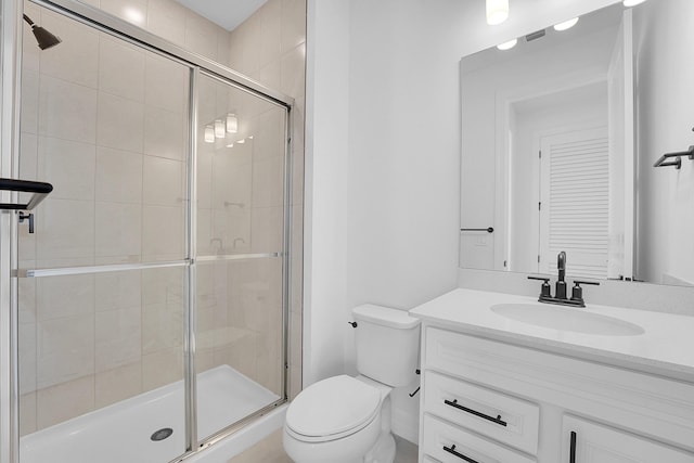 bathroom featuring vanity, toilet, and a shower with shower door