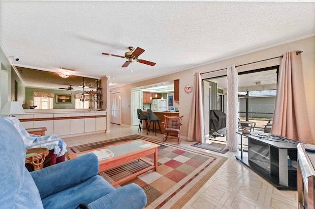 living room featuring ceiling fan, plenty of natural light, and a textured ceiling