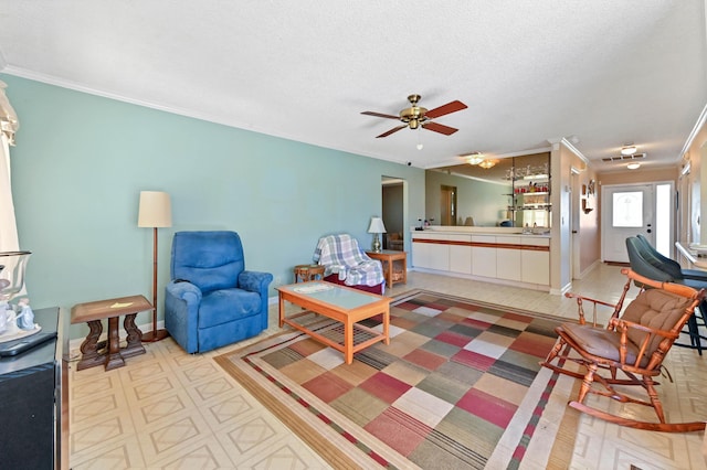 living room with a textured ceiling, ceiling fan, crown molding, and sink