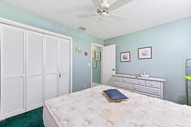 bedroom featuring ceiling fan, a closet, dark carpet, and a textured ceiling