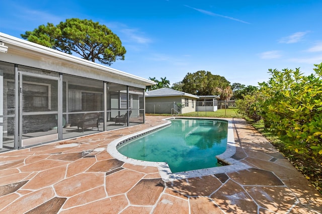 view of swimming pool with a patio area and a sunroom