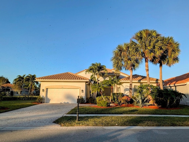 mediterranean / spanish-style home with a front yard and a garage