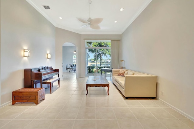 living room featuring ceiling fan, light tile patterned floors, and ornamental molding