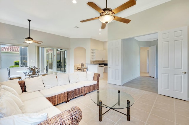 tiled living room with ceiling fan and ornamental molding