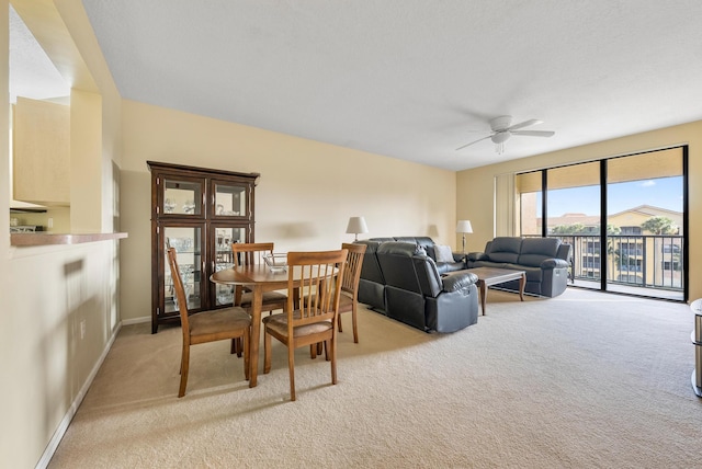 carpeted dining room with ceiling fan