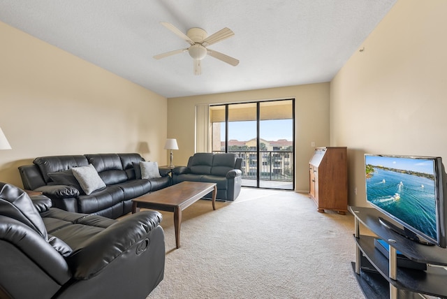 living room with ceiling fan, light colored carpet, and a textured ceiling