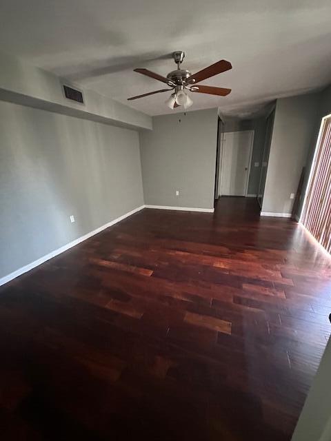 spare room featuring ceiling fan and dark hardwood / wood-style floors