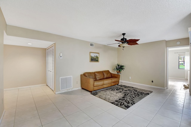 tiled living room featuring a textured ceiling and ceiling fan