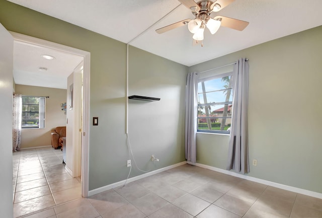 unfurnished room with plenty of natural light, ceiling fan, and light tile patterned floors