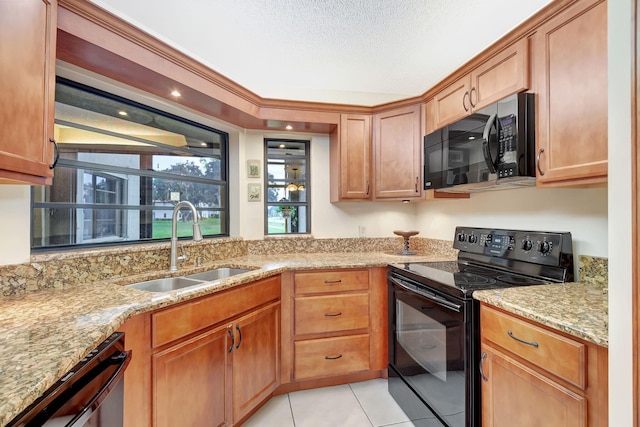 kitchen with black appliances, light tile patterned flooring, light stone counters, and sink