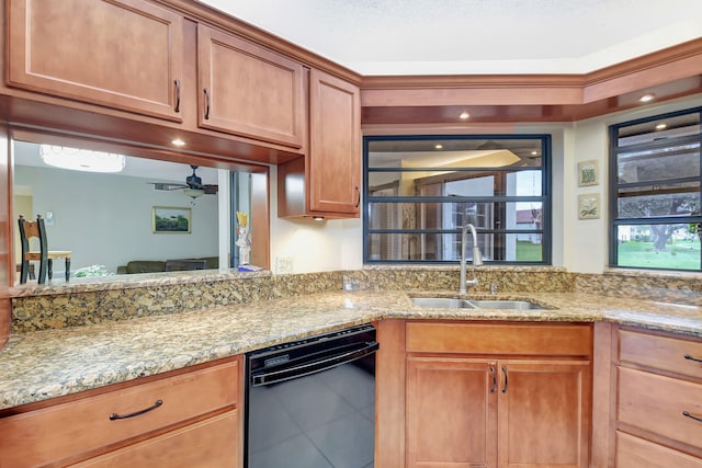 kitchen with tile patterned floors, light stone counters, ceiling fan, sink, and dishwasher