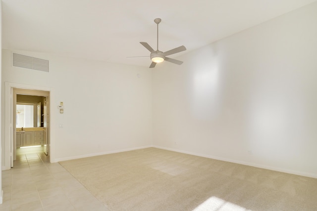 spare room featuring ceiling fan and light carpet