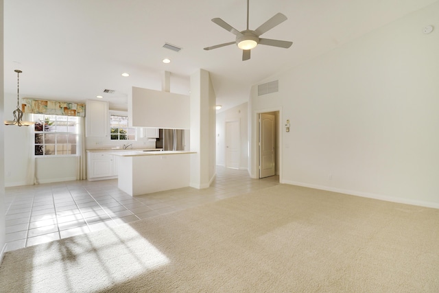 unfurnished living room with light tile patterned floors and ceiling fan with notable chandelier