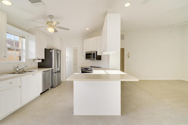 kitchen with white cabinets, stainless steel appliances, ceiling fan, and sink