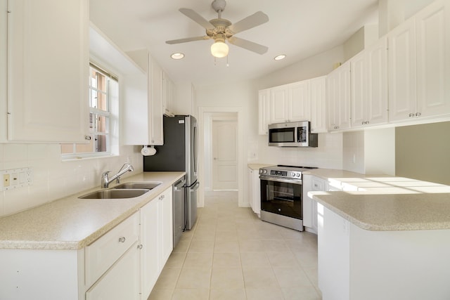 kitchen featuring white cabinetry, sink, ceiling fan, stainless steel appliances, and light tile patterned flooring