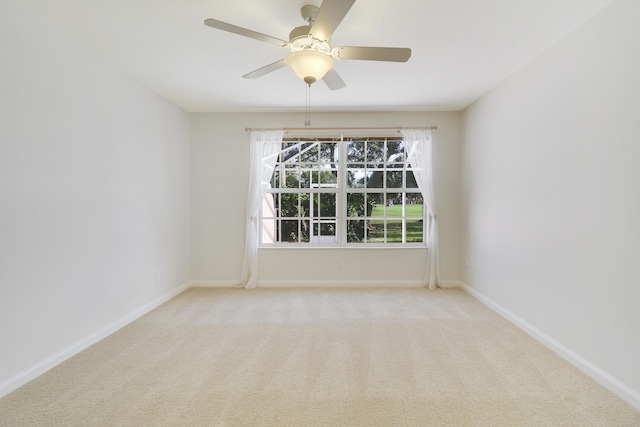 empty room featuring ceiling fan and light colored carpet