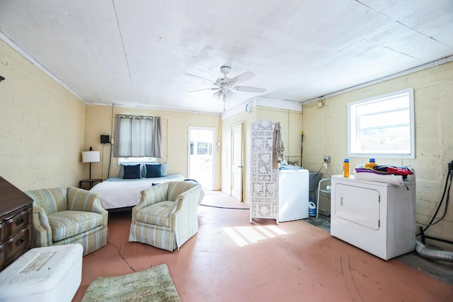 interior space featuring multiple windows, washer and clothes dryer, ceiling fan, and concrete flooring