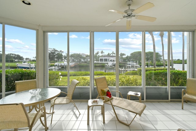 sunroom / solarium featuring a water view, ceiling fan, and a healthy amount of sunlight