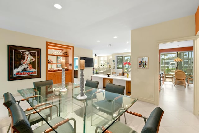 tiled dining area featuring built in features and plenty of natural light