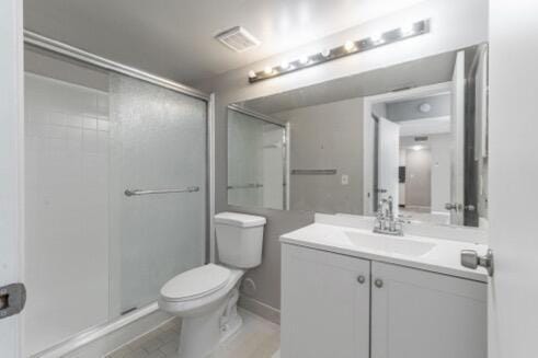 bathroom featuring toilet, vanity, and an enclosed shower