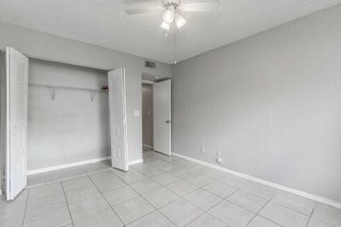 unfurnished bedroom with ceiling fan and a closet