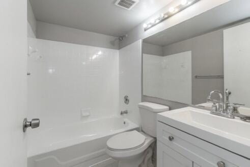 full bathroom featuring toilet, vanity, and  shower combination