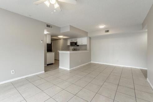 unfurnished living room featuring ceiling fan and light tile patterned flooring