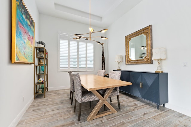 9289 SW Miracoli Way, Port Saint Lucie, FL 34987 - dining space featuring a chandelier, light wood-style flooring, baseboards, and a tray ceiling