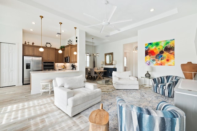 living room featuring light hardwood / wood-style floors, ceiling fan, and sink