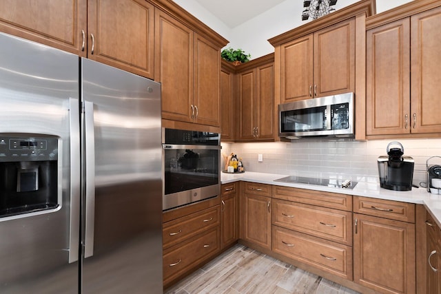 kitchen featuring backsplash, stainless steel appliances, and light hardwood / wood-style flooring