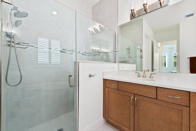 bathroom with vanity and a shower with shower door