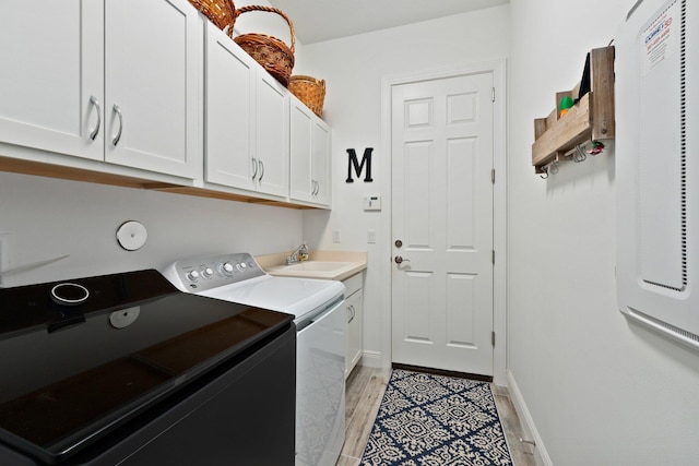 laundry area with cabinets, independent washer and dryer, light hardwood / wood-style flooring, and sink