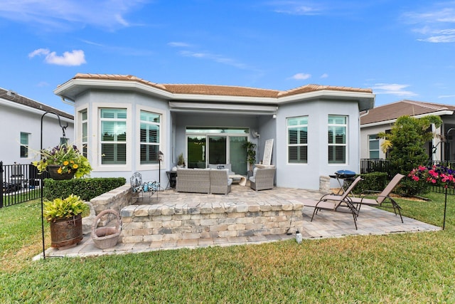 back of property with outdoor lounge area, a patio, and a lawn