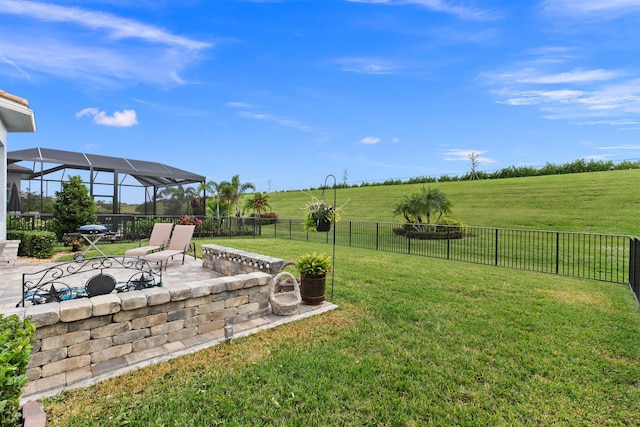 view of yard featuring glass enclosure, a rural view, and a patio