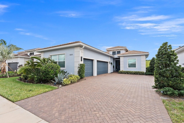 9289 SW Miracoli Way, Port Saint Lucie, FL 34987 - view of front facade featuring an attached garage, decorative driveway, stucco siding, and a front yard